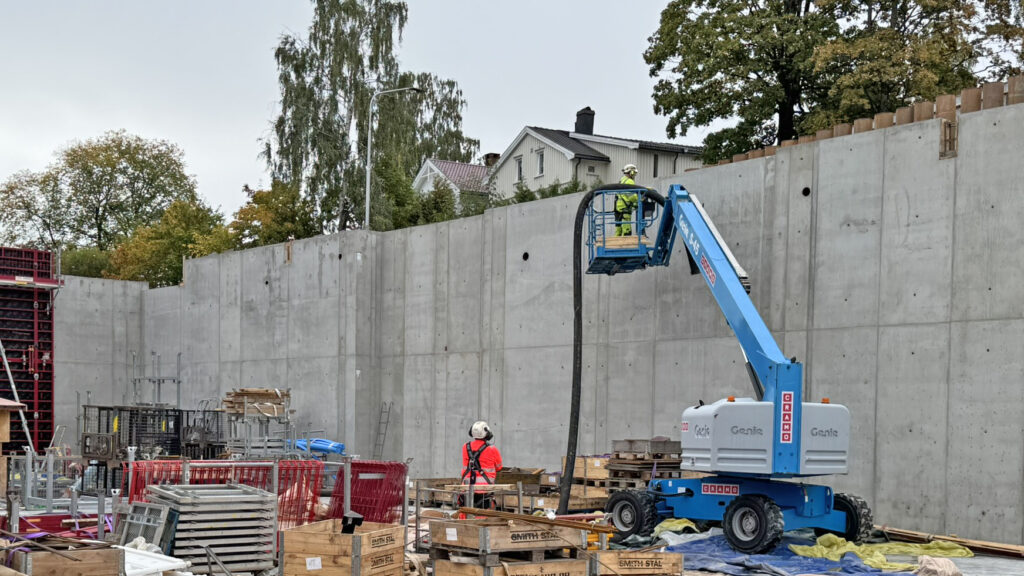 Blåseslangen ble heiset over betongveggen med lift.